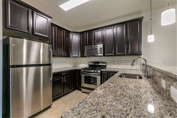A kitchen with stainless steel appliances and granite counter tops
